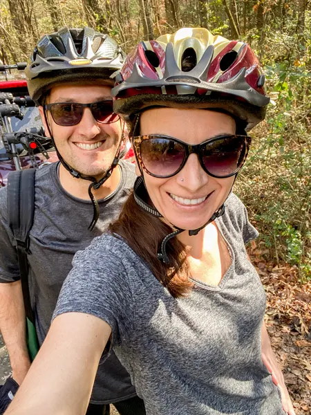 Bent Creek Experimental Forest Mountain Biking In Asheville NC with white brunette male and female wearing bike helmets in gray shirts with sunglasses