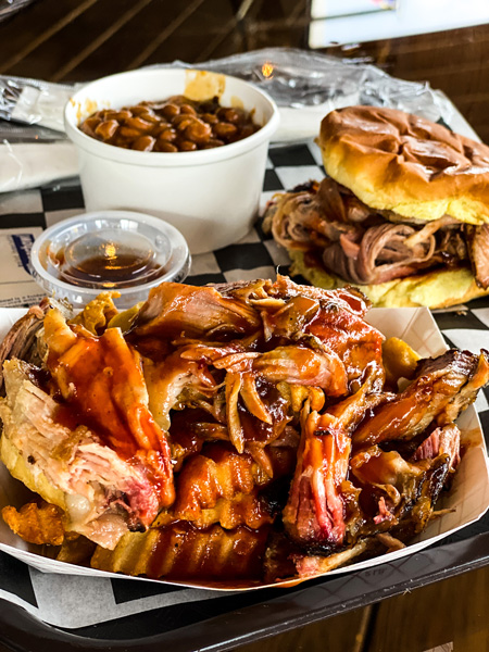 Carolina Ace Catering with picture of pulled pork BBQ fries, pulled pork sandwich, and baked beans on metal plate