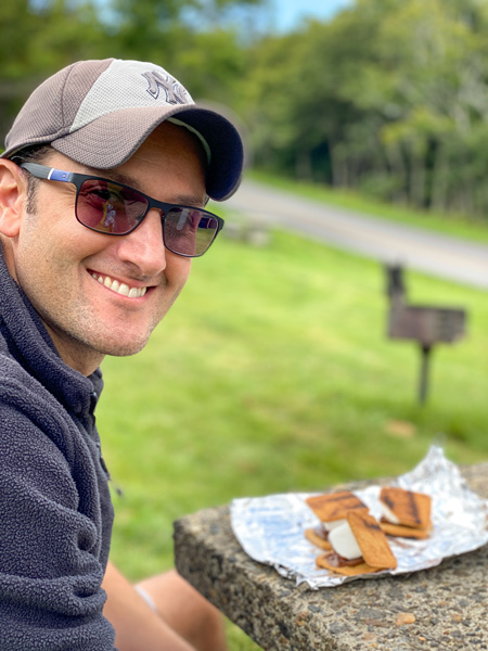 Craggy Gardens Picnic Area Blue Ridge Parkway smores on picnic table with white brunette male in black fleece