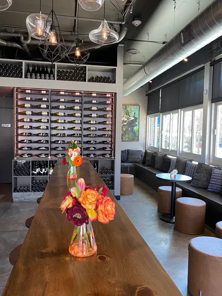 Marked Tree Vineyard Asheville Tasting Room with wine bottles on wall, orange flowers and tables with chairs