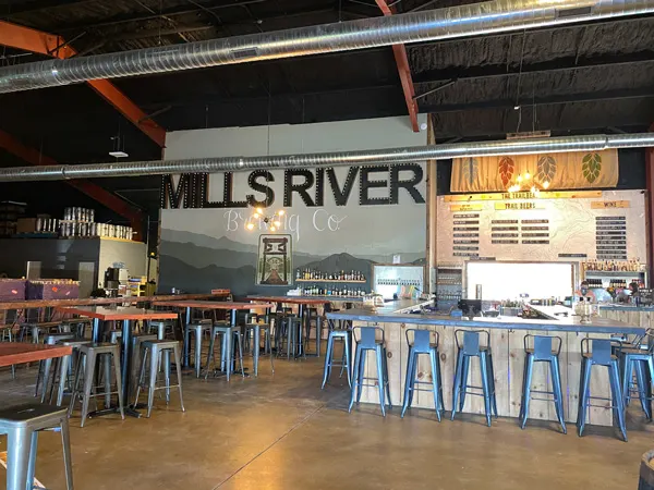Mills River Brewing Co Taproom with bar, bar tables, craft beer taps, and bar seating.