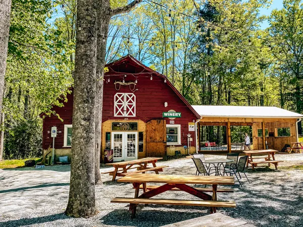 Sawyer Springs Vineyard Hendersonville NC with red barn, picnic tables, and tree