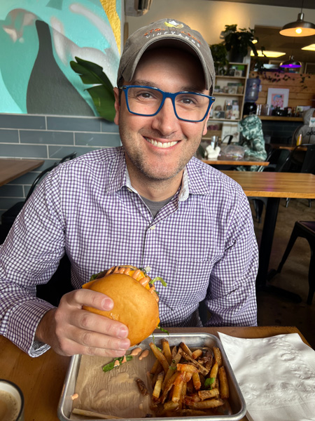 Tom eating a The Smokin' Onion vegan burger