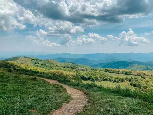 Appalachian Trail Max Patch Hike with dirt path, blue mountains, and green trees
