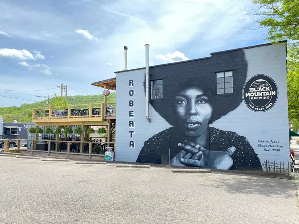 Black Mountain Brewing Roberta Flack Mural with portrait of Flack and upper and lower deck with brewing building