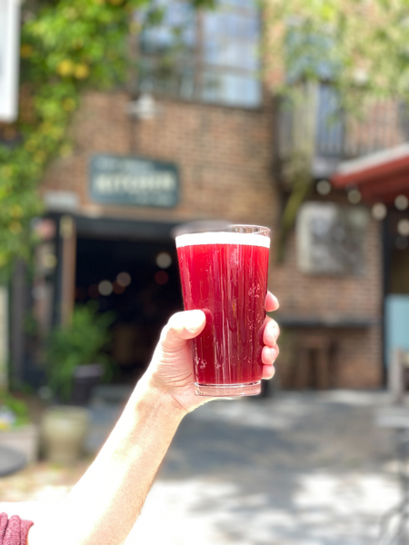 Black Mountain Kitchen And Ale House with white hand and arm holding up red beer glass