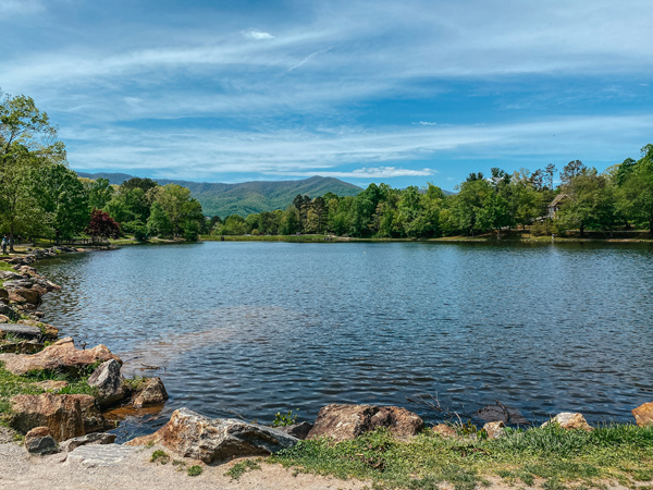 Lake Tomahawk Black Mountain NC with mountains, tree, and blue lake with rock border