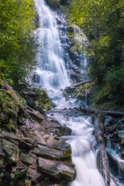 Mingo Falls Trail Cherokee NC with cascading waterfall, rocks, and green trees