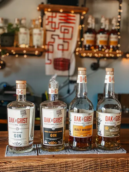Oak and Grist Distilling Company Black Mountain NC with four bottles of whiskey and gin on a bar