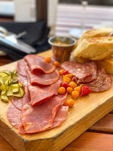 Charcuterie The Great Hall Bar Grove Park Inn with three different types of meats, pickles, bread, and red and orange peppers