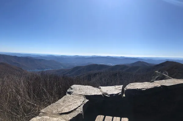Craggy Pinnacle Trail Blue Ridge Parkway NC with benches, stone wall, and view of Blue Ridge Mountains and Asheville reservoir