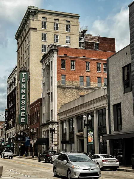 Downtown Knoxville TN Gay Street with buildings and cars on road with sign that says Tennessee