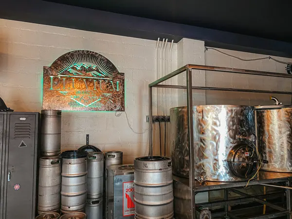 Eluvium Brewing Company with sign and steel brewing tanks