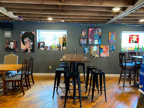 Eurisko Beer Company Taproom Asheville NC with tables, chairs, and gray walls with artwork