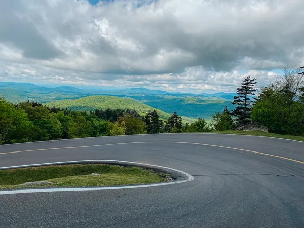 Forrest Gump Curve Grandfather Mountain with blue and green mountains in the distance behind curved paved road