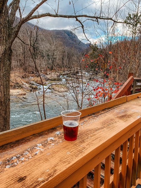 Hickory Nut Brewery Chimney Rock with beer on wooden deck overlooking river