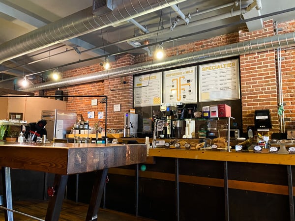 High Five Coffee Asheville NC with coffee bar, menu on wall, and tables