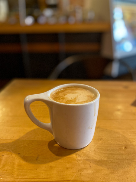 High Five Coffee Downtown Asheville NC cup of coffee in white mug on brown table