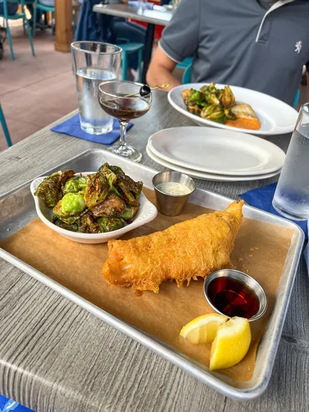 Jettie Rae's Oyster House Asheville NC Restaurant with breaded fish on silver tray with Brussels sprouts, cocktail sauce, and lemon garnish