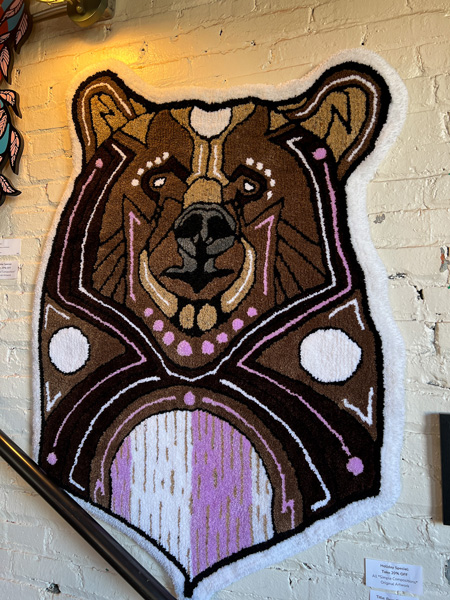 Summit Coffee Shop in Asheville NC Bear Rug Art - brown bear with pink and white stomach - on white brick wall above hand-railing