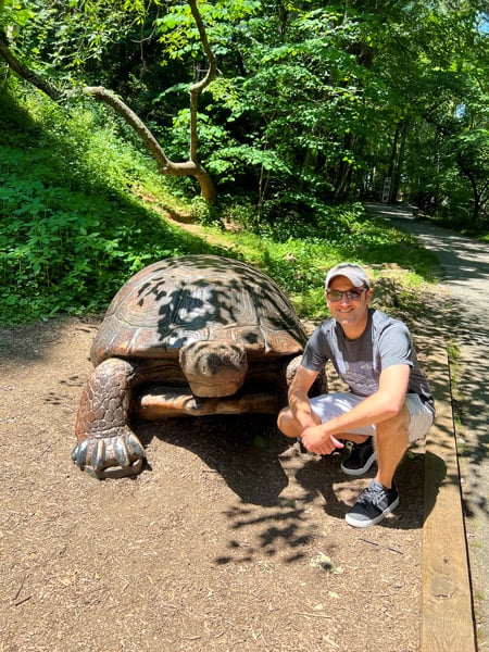 WNC Nature Center Asheville NC turtle sculpture with white male squatting next to it