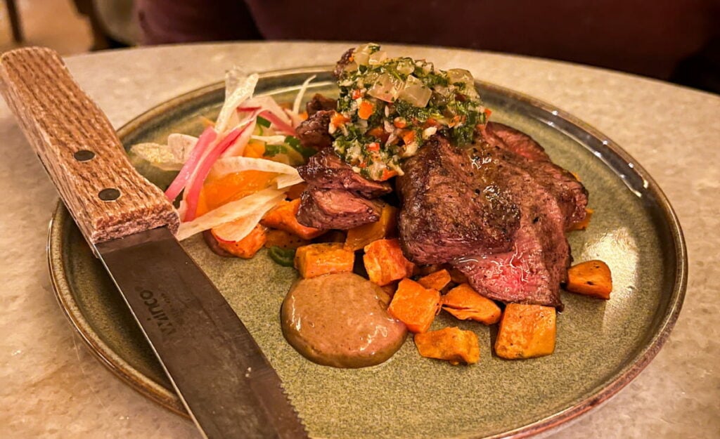 Best Black Mountain Restaurants article featured image with flat-iron steak on plate with vegetables and large steak knife at The Pure and Proper in Black Mountain, NC