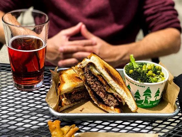 Black Mountain Kitchen and Ale House Burgers with glass filled with red cider and burger on gluten free bread with southern sides