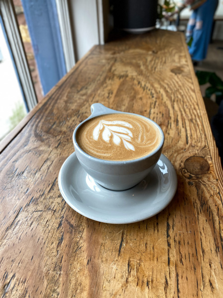 Dripolator Coffeehouse Black Mountain NC Mocha Latte with leaf pattern in foam on wooden bar