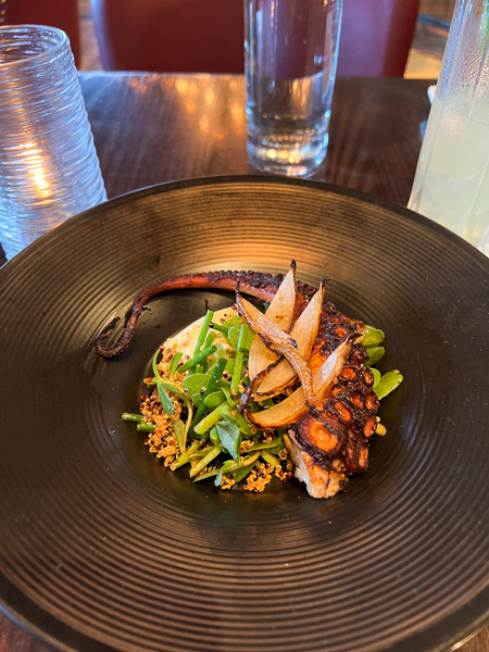 Grilled octopus in a black bowl over salad at Posana, a dedicated gluten-free restaurant in Asheville, NC