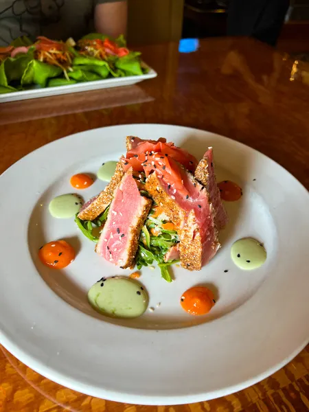 Stoney Knob Cafe Weaverville NC Tuna standing up on pile of grab salad on white plate garnished with wasabi sauce and red hot sauce