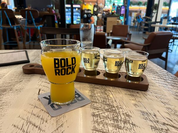 Bold Rock Cider Asheville North Carolina Flight of 4 yellow cider and yellow cider mimosa in front on table in taproom