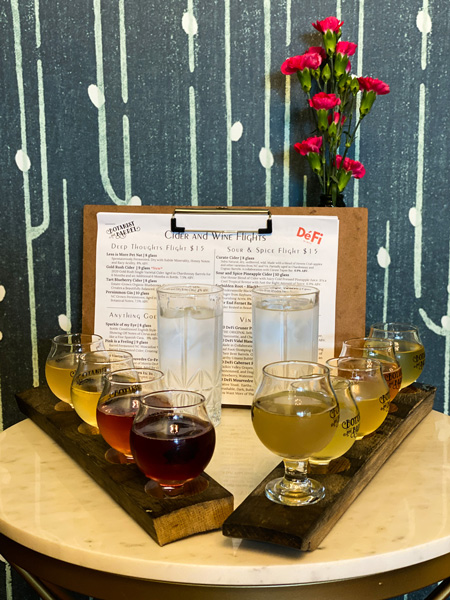 Botanist and Barrel Cidery in Asheville with cider flight on table