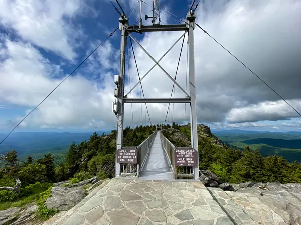 Grandfather Mountain Mile High Swinging Bridge surrounded by blue and green mountains