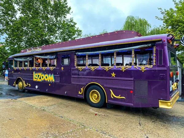 LaZoom Comedy Bus Tours Purple Bus with yellow accents and open windows