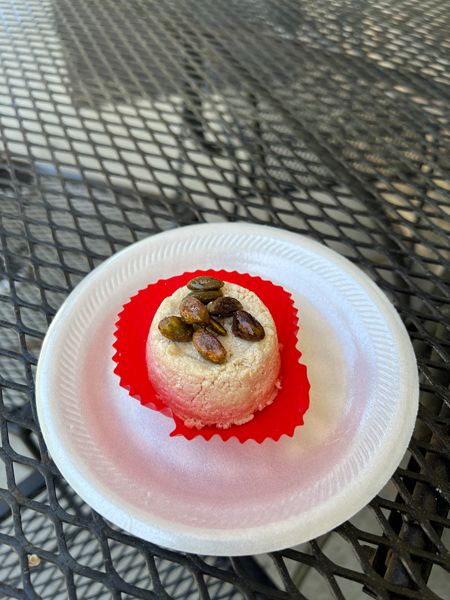 Pita Express Dessert Hendersonville NC with gluten free and vegan white cookie topped with nuts in a sauce on styrofoam plate with red wrapping
