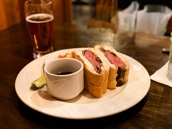 Shine Restaurant Hendersonville NC with picture of French dip roast beef sandwich on white plate with amber Sierra Nevada Oktoberfest beer, pickle, and side of fruit