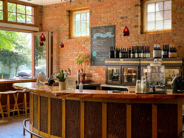 5 Walnut Wine Bar Asheville NC with dark wooden bar, brick back wall, menu, and wine bottles