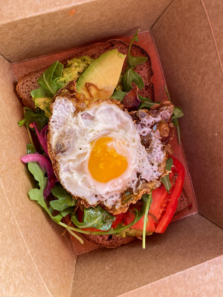 BimBeriBon Breakfast West Asheville with egg on top of gluten free avocado toast with tomatoes and picked onions