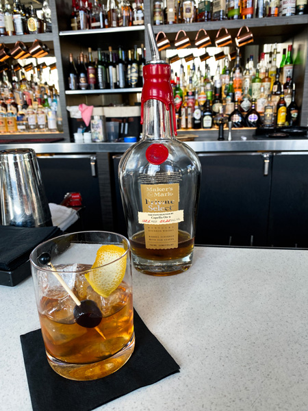 Capella On 9 Rooftop Bar Asheville NC with Maker's Mark Bourbon on bar next to classic Old Fashioned craft cocktail