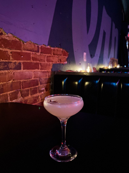 Cocktail The Malvern Bar West Asheville NC with dark lighting and drink in martini glass garnished with anise