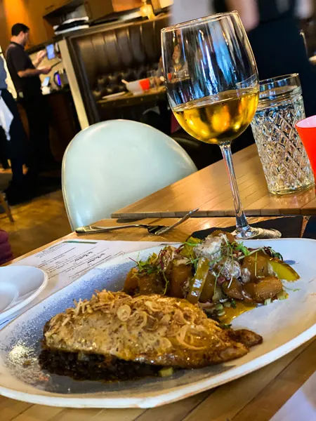 Jargon Fine Dining Restaurant West Asheville with plate of meat and sauce with veggies and white wine glass