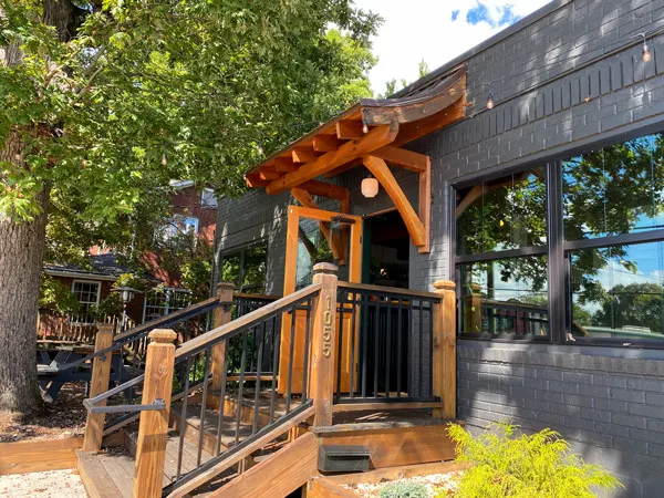 Leos House Of Thirst West Asheville with gray building and light wood stairway going up to front door