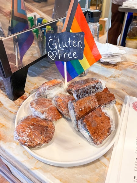 Liberty House Cafe in Asheville NC Gluten Free Treats wrapped in clear cellophane on counter at register with little rainbow Pride flag