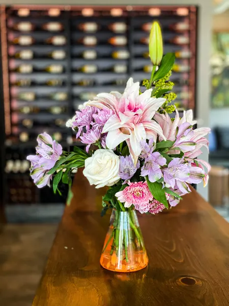 Marked Tree Vineyard Downtown Asheville Wine Bar with purple, white, and pink flowers on table