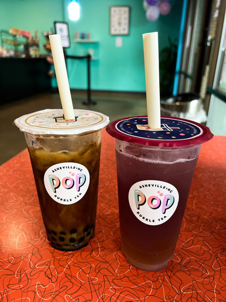 Pop Bubble Tea Asheville NC two bobas on table, one with brown coloring and tapioca and the other with pink hue