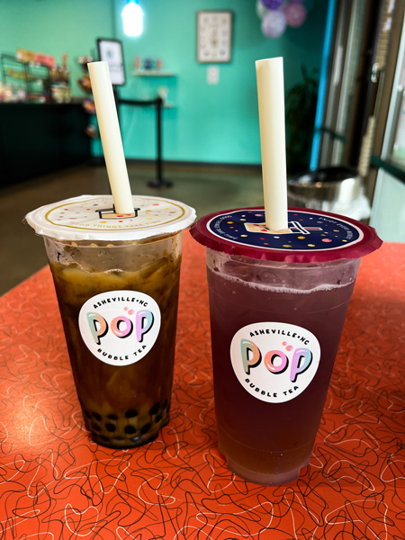 Pop Bubble Tea Asheville NC two bobas on table, one with brown coloring and tapioca and the other with pink hue