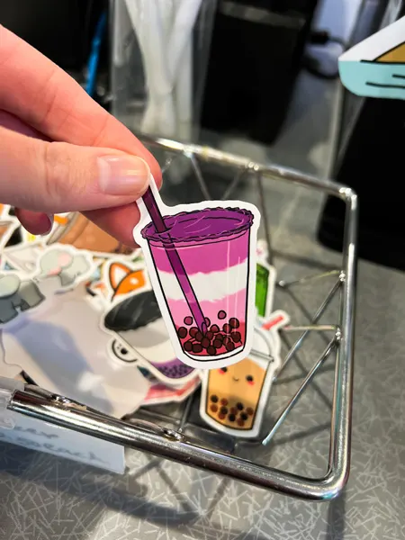 Pop Bubble Tea Asheville NC Sticker with purple, white and pink boba in front of metal basket
