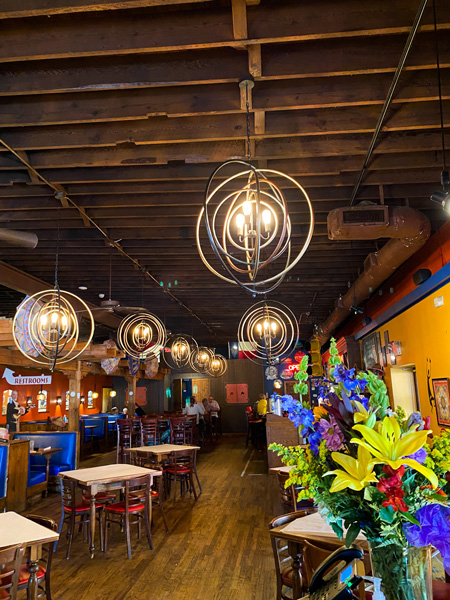 The Cantina Mexican Restaurant Asheville NC with picture of circular lights, colorful flowers, and tables