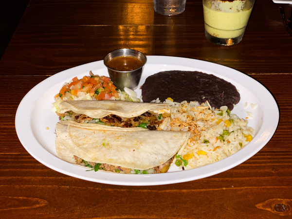 The Cantina Tacos Asheville NC with two soft-shell tacos on plate, rice, salsa, and black beans