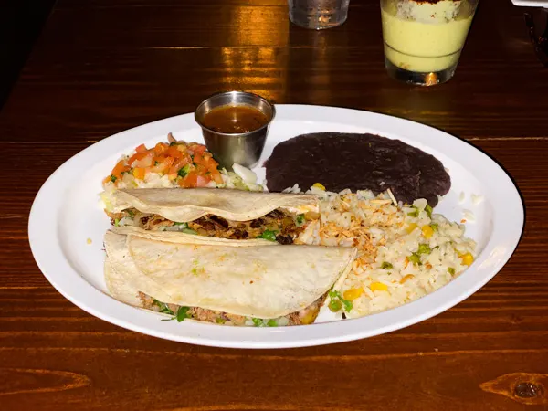 The Cantina Tacos Asheville NC with two soft-shell tacos on plate, rice, salsa, and black beans